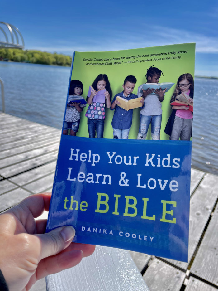 Reading "Help Your Kids Learn & Love the Bible" by the lake. Learn more about the book for moms and get a free tool kit.